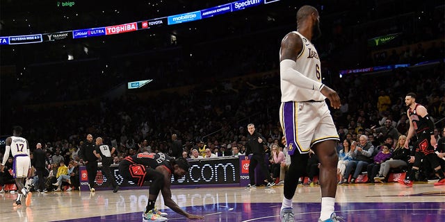 Patrick Beverley (21) of the Chicago Bulls touches the Los Angeles Lakers' court as he celebrates after scoring a basket against LeBron James (6) of the Lakers in the closing minute of a game at Crypto.com Arena March 26, 2023, in Los Angeles.