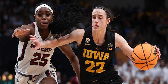 Caitlin Clark (22) of the Iowa Hawkeyes dribbles against Raven Johnson (25) of the South Carolina Gamecocks during the third quarter of the 2023 NCAA Tournament's Final Four at American Airlines Center March 31, 2023, in Dallas, Texas.