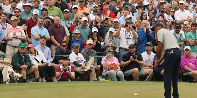 Patrons look on as Tiger Woods of the United States putts on the ninth green during a practice round prior to the 2023 Masters Tournament at Augusta National Golf Club on April 04, 2023 in Augusta, Georgia. 