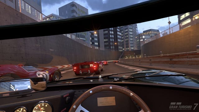 A cockpit view of racing on a highway in the video game Gran Turismo 7