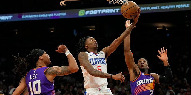 Los Angeles Clippers' Bones Hyland drives between the Suns' Damion Lee and Josh Okogie, Sunday, April 9, 2023, in Phoenix.