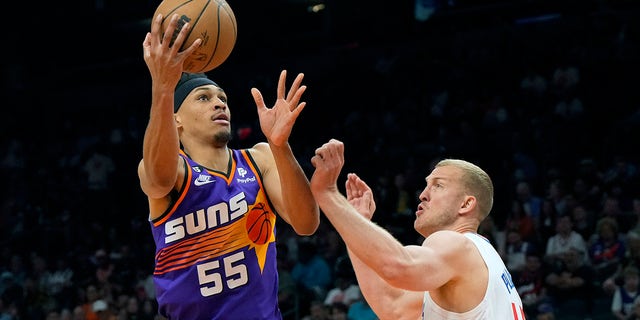 Suns forward Darius Bazley drives around LA Clippers center Mason Plumlee, Sunday, April 9, 2023, in Phoenix.