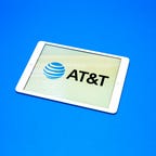 AT&T logo of blue earth with horizontal white lines on a tablet