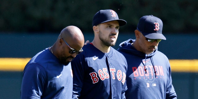 Adam Duvall #18 of the Boston Red Sox, center, leaves the game against the Detroit Tigers with manager Alex Cora #21 and a trainer after injuring his wrist while attempting a sliding catch during the ninth inning of the game at Comerica Park on April 9, 2023, in Detroit, Michigan.