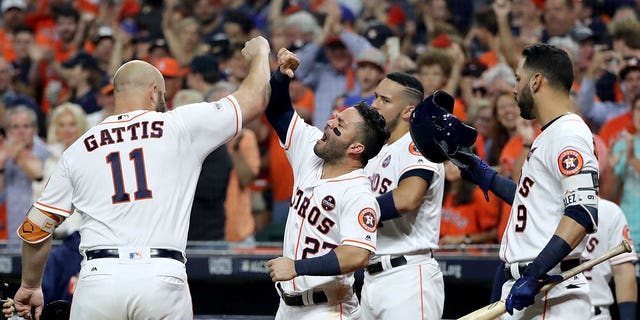 Evan Gattis #11 of the Houston Astros celebrates with Jose Altuve #27, Carlos Correa #1 and Marwin Gonzalez #9 after hitting a solo home run against CC Sabathia #52 of the New York Yankees during the fourth inning in Game Seven of the American League Championship Series at Minute Maid Park on October 21, 2017 in Houston, Texas.  