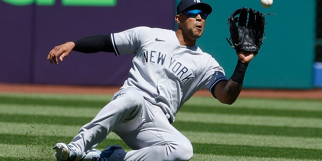 Aaron Hicks #31 of the New York Yankees makes a sliding catch to get out Amed Rosario #1 of the Cleveland Guardians during the first inning at Progressive Field on April 12, 2023 in Cleveland, Ohio.