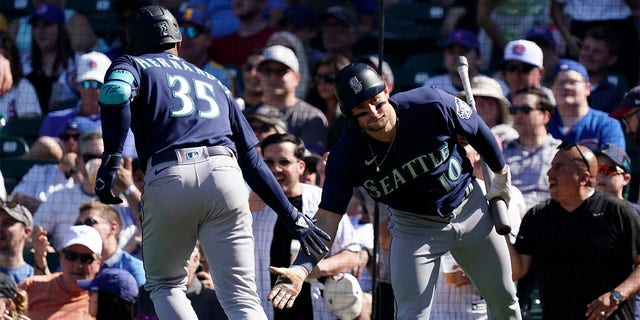 Teoscar Hernandez of the Seattle Mariners is congratulated by Jarred Kelenic during the Cubs game at Wrigley Field on April 12, 2023, in Chicago.