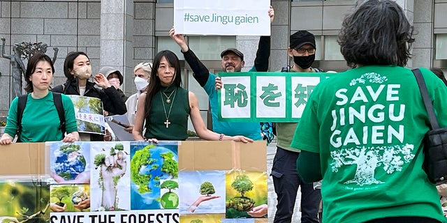 People gather in front of the Tokyo Metropolitan Government Building, Sunday, April 9, 2023, as they protest the Meiji Jingu Gaien area redevelopment project.