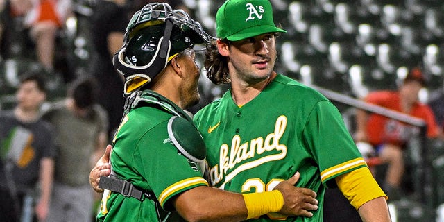 Relief pitcher Chad Smith is congratulated by catcher Carlos Perez at the end of the Oakland Athletics' win over the Orioles on April 12, 2023, in Baltimore.