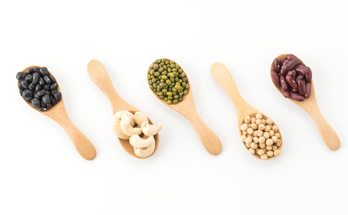 Various beans and nuts on a set of spoons.