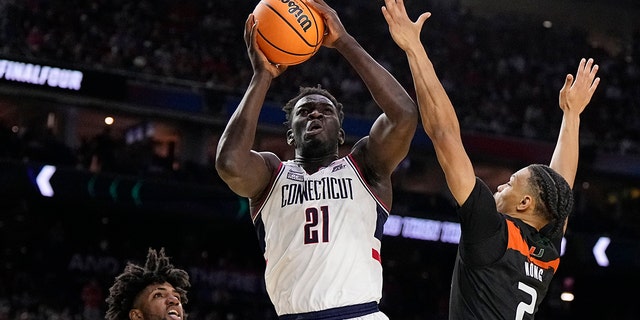 Connecticut forward Adama Sanogo scores past Miami guard Isaiah Wong during the second half of a Final Four game in the NCAA Tournament April 1, 2023, in Houston.