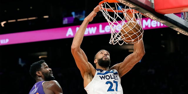 Minnesota Timberwolves center Rudy Gobert (27) dunks against Phoenix Suns center Deandre Ayton (22) during the first half of a game March 29, 2023, in Phoenix. 