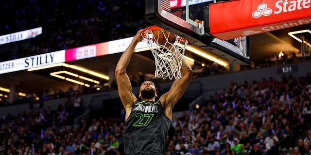 Rudy Gobert #27 of the Minnesota Timberwolves dunks the ball on an alley-oop while Shai Gilgeous-Alexander #2 of the Oklahoma City Thunder looks on in the second quarter of the NBA Play-In game at Target Center on April 14, 2023, in Minneapolis, Minnesota.