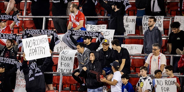 Members of the Viking Army supporters of the New York Red Bulls hold signs and scarves at the start of the Major League Soccer match against Houston Dynamo FC.