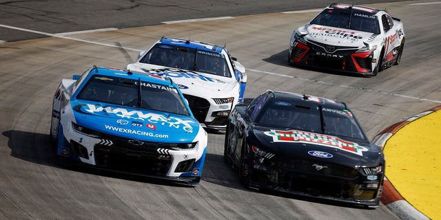 Kevin Harvick, driver of the #4 Realtree/Hunt Brothers Pizza Ford, Ross Chastain, driver of the #1 Unishippers Chevrolet, Chase Briscoe, driver of the #14 HighPoint.com Ford, and Denny Hamlin, driver of the #11 Sport Clips Haircuts Toyota, race during the NASCAR Cup Series NOCO 400 at Martinsville Speedway on April 16, 2023 in Martinsville, Virginia.