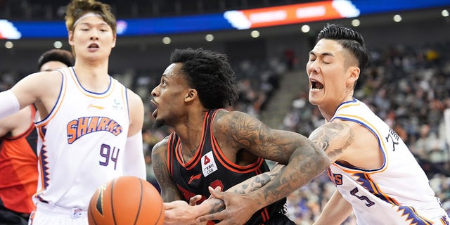 Antonio Blakeney of Jiangsu Dragons vies for the ball against the Sharks in east China's Shanghai, April 9, 2023.