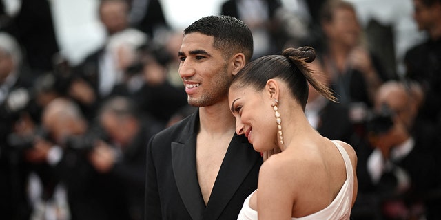 Moroccan defender Achraf Hakimi (L) and his wife Hiba Abouk arrive for the screening of the film "The Innocent (L'Innocent)" during the 75th edition of the Cannes Film Festival in Cannes, southern France, on May 24, 2022.