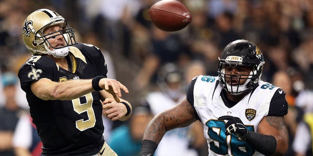 Drew Brees of the Saints is pursued by Chris Smith of the Jacksonville Jaguars at the Mercedes-Benz Superdome on Dec. 27, 2015, in New Orleans.