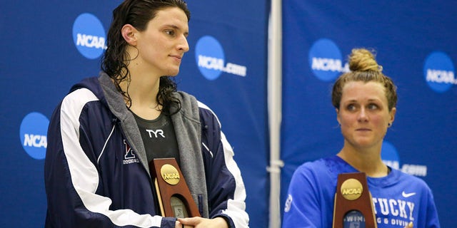 Penn Quakers swimmer Lia Thomas, left, holds a trophy after finishing fifth in the 200 free at the NCAA Swimming &amp; Diving Championships as Kentucky Wildcats swimmer Riley Gaines looks on at Georgia Tech in Atlanta March 18, 2022.