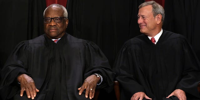 United States Supreme Court Associate Justice Clarence Thomas, left, and Chief Justice John Roberts pose for their official portrait at the East Conference Room of the Supreme Court building Oct. 7, 2022, in Washington, D.C.