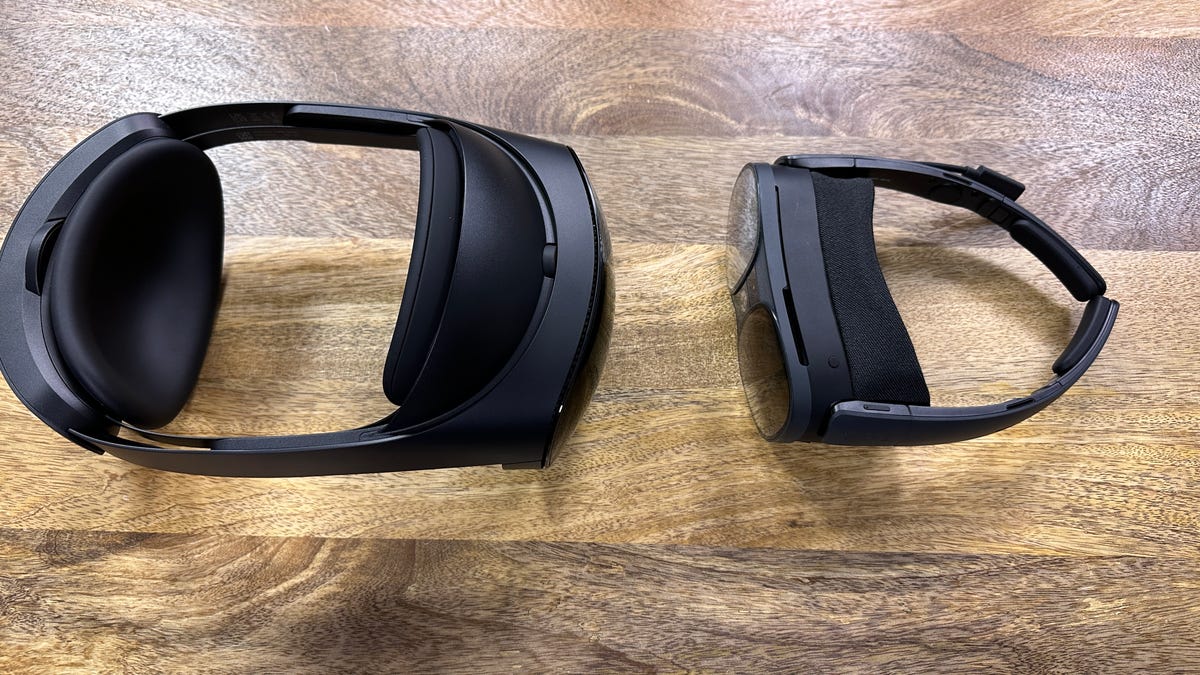 HTC Vive XR Elite and Meta Quest Pro VR headsets on a wooden table, facing each other