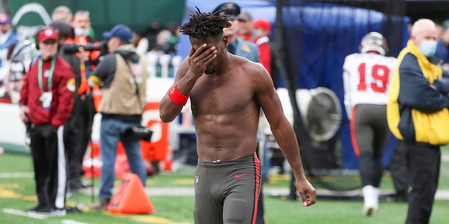 Tampa Bay Buccaneers wide receiver Antonio Brown wipes his face as he leaves the field after throwing his equipment into the stands while his team is on offense during the third quarter of an NFL football game against the New York Jets, Sunday, Jan. 2, 2022, in East Rutherford, New Jersey.