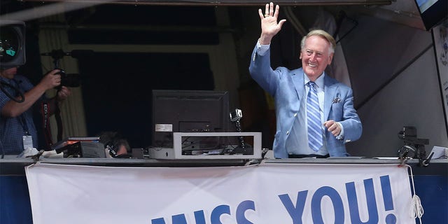 Los Angeles Dodgers broadcaster Vin Scully waves to the crowd after leading in the singing of "Take Me Out to the Ball Game" during the seventh inning stretch of the game with the Colorado Rockies at Dodger Stadium on September 24, 2016 in Los Angeles. The Dodgers won 14-1.