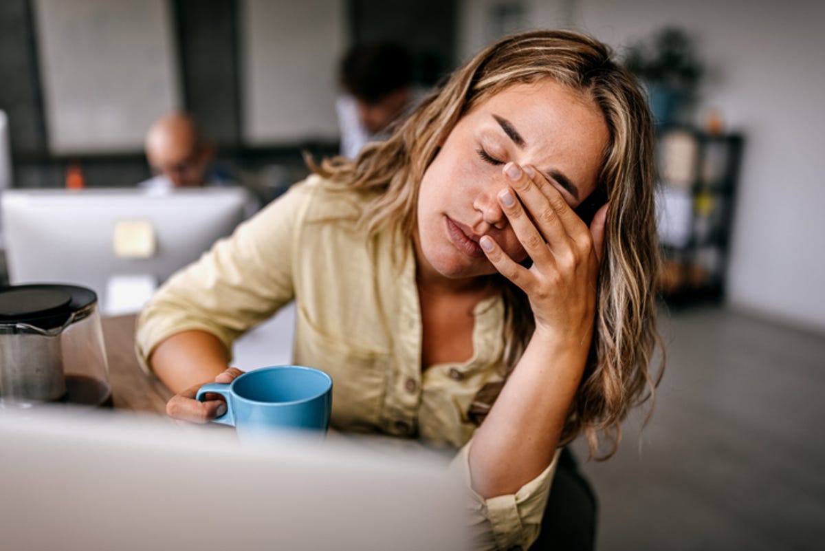 Woman rubbing her eye because she has a headache.