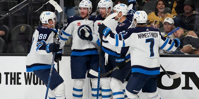 Winnipeg Jets celebrate after right wing Blake Wheeler, center, scored against the Vegas Golden Knights during the third period of Game 1 of an NHL hockey Stanley Cup first-round playoff series Tuesday, April 18, 2023, in Las Vegas. 