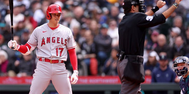 Umpire Pat Hoberg calls Shohei Ohtani of the Los Angeles Angels for a pitch clock violation during the sixth inning against the Seattle Mariners at T-Mobile Park April 5, 2023, in Seattle. 