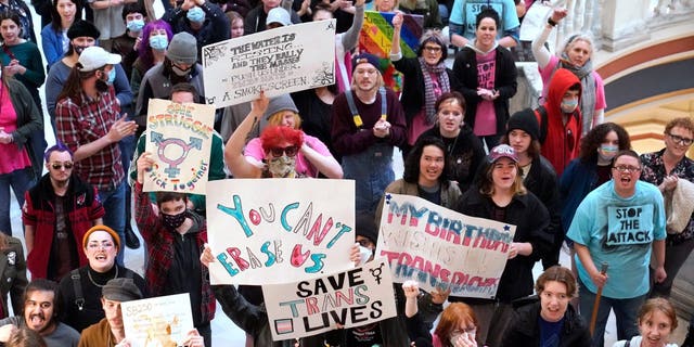 Trans-rights activists protest outside the House chamber at the state Capitol