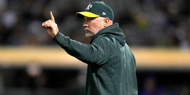 Manager Mark Kotsay signals the bullpen to make a pitching change against the New York Mets in the top of the fourth inning at RingCentral Coliseum on April 14, 2023, in Oakland, California. 