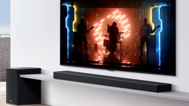 A TV on a white wall with an LG SP8YA soundbar and subwoofer.