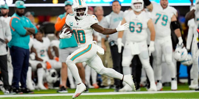 Miami Dolphins wide receiver Tyreek Hill (10) runs for a touchdown after recovering a fumble during a game against the Los Angeles Chargers Dec. 11, 2022, in Inglewood, Calif. 