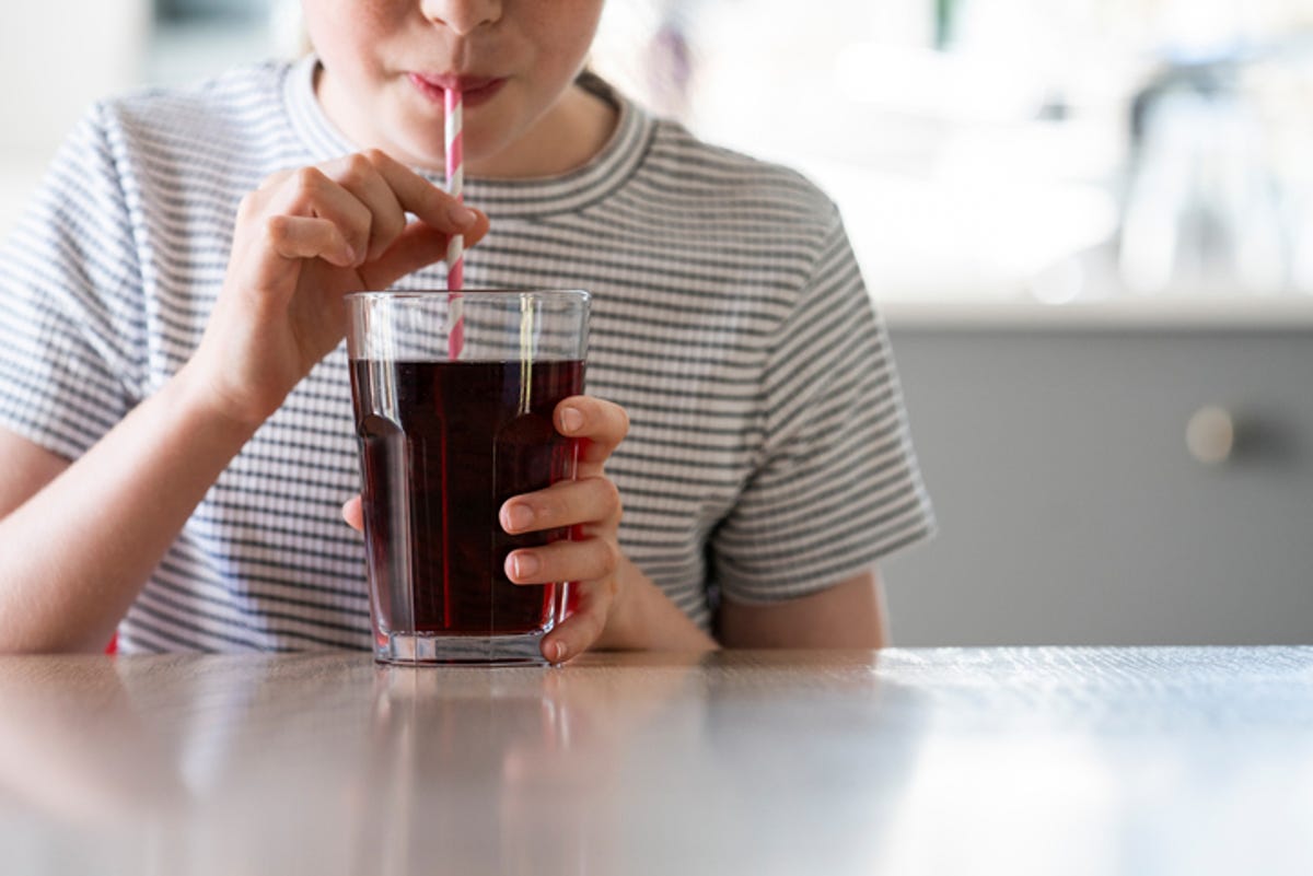 Child drinking a soda through a straw.