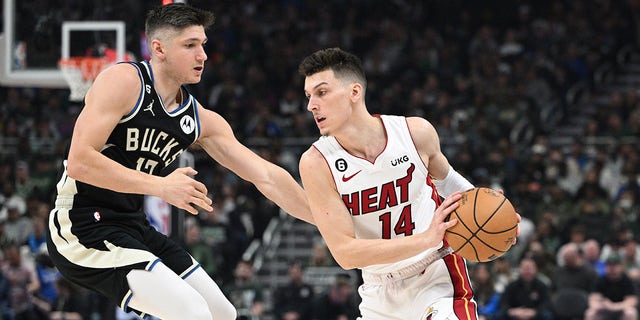 Apr 16, 2023; Milwaukee, Wisconsin, USA; Miami Heat guard Tyler Herro (14) drives against Milwaukee Bucks guard Jrue Holiday (21) in the first half during game one of the 2023 NBA Playoffs at Fiserv Forum.