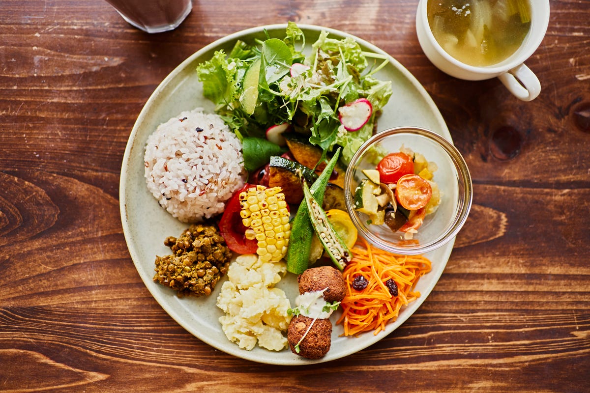 A plate with rice, corn, okra, fresh greens and other produce.