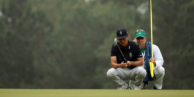 Kevin Na of the United States talks with his caddie Kenneth Harms on the third green during the first round of the 2023 Masters Tournament at Augusta National Golf Club April 6, 2023, in Augusta, Ga. 