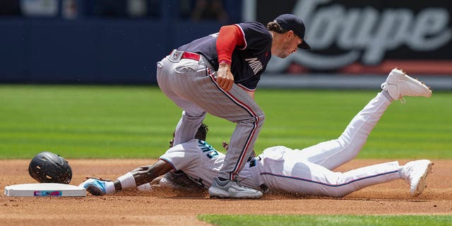 A sliding Jazz Chisholm Jr. of the Miami Marlins is tagged by Kyle Farmer of the Minnesota Twins while attempting to steal second base during the first inning against the Minnesota Twins at loanDepot Park April 5, 2023, in Miami, Fla. 