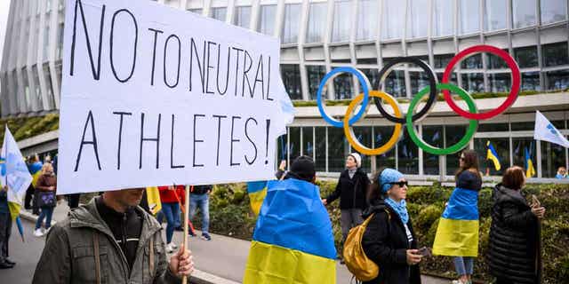 Members of the Geneva branch of Ukrainian society protest during a rally to urge the International Olympic Committee to reconsider their decision of participation of Russian and Belarusian athletes at the next 2024 Paris Olympic Games.