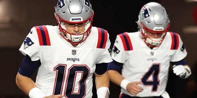 Mac Jones, left, and Bailey Zappe of the New England Patriots take the field for the Cardinals game at State Farm Stadium on Dec. 12, 2022, in Glendale, Arizona.