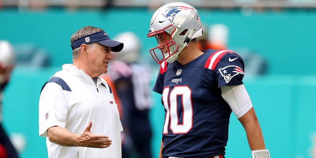 Head coach Bill Belichick and Mac Jones, #10, look on during pregame at Hard Rock Stadium on Sept. 11, 2022 in Miami Gardens, Florida.