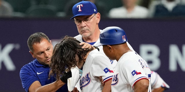 Apr 3, 2023; Arlington, Texas, USA; Texas Rangers left fielder Josh Smith (47) leaves the game after getting hit by a pitch thrown by Baltimore Orioles relief pitcher Danny Coulombe (not shown) during the third inning at Globe Life Field.