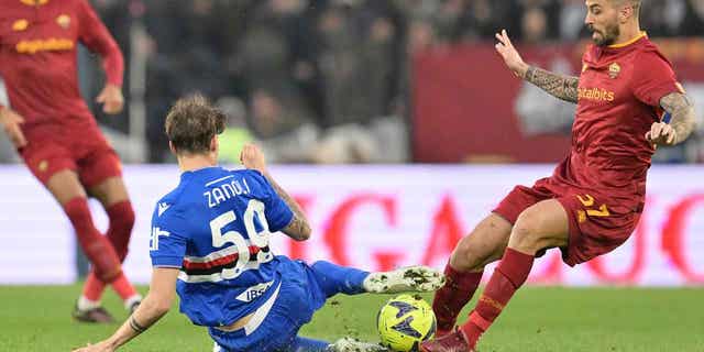 Leonardo Spinazzola, right, is tackled by Sampdorias Alessandro Zanoli in a soccer match between Roma and Sampdoria at the Rome Olympic stadium on April 2, 2023.