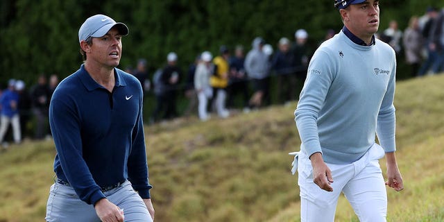 Rory McIlroy of Northern Ireland, left, and Justin Thomas of the United States walk across the 18th hole during the first round of The Genesis Invitational at Riviera Country Club Feb. 16, 2023, in Pacific Palisades, Calif.