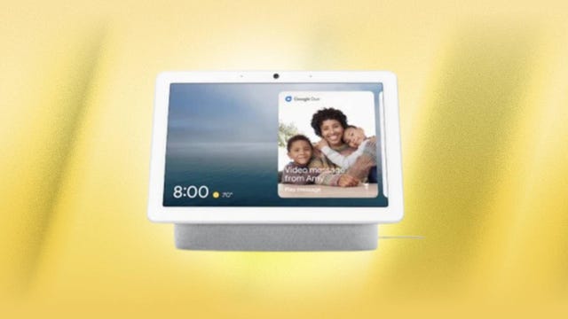 The Google Nest Hub Max smart display is displayed against a yellow background.