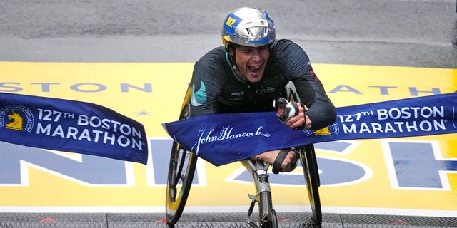 Marcel Hug, of Switzerland, breaks the tape winning the men's wheelchair division of the 127th Boston Marathon, on April 17, 2023.