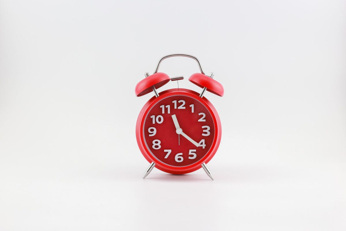 Alarm clock in red, with bell ringers on top