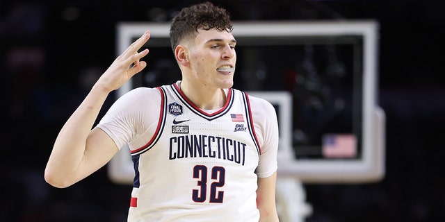 Donovan Clingan #32 of the Connecticut Huskies reacts after teammate Joey Calcaterra #3 (not pictured) makes a three-point basket during the second half against the San Diego State Aztecs during the NCAA Men's Basketball Tournament National Championship game at NRG Stadium on April 03, 2023 in Houston, Texas. 