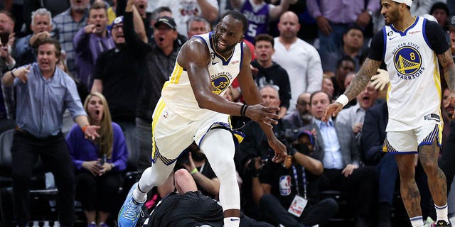 Draymond Green #23 of the Golden State Warriors steps over Domantas Sabonis #10 of the Sacramento Kings in the second half during Game Two of the Western Conference First Round Playoffs at Golden 1 Center on April 17, 2023 in Sacramento, California. Green was issued a flagrant foul 2 on the play, and ejected from the game. 